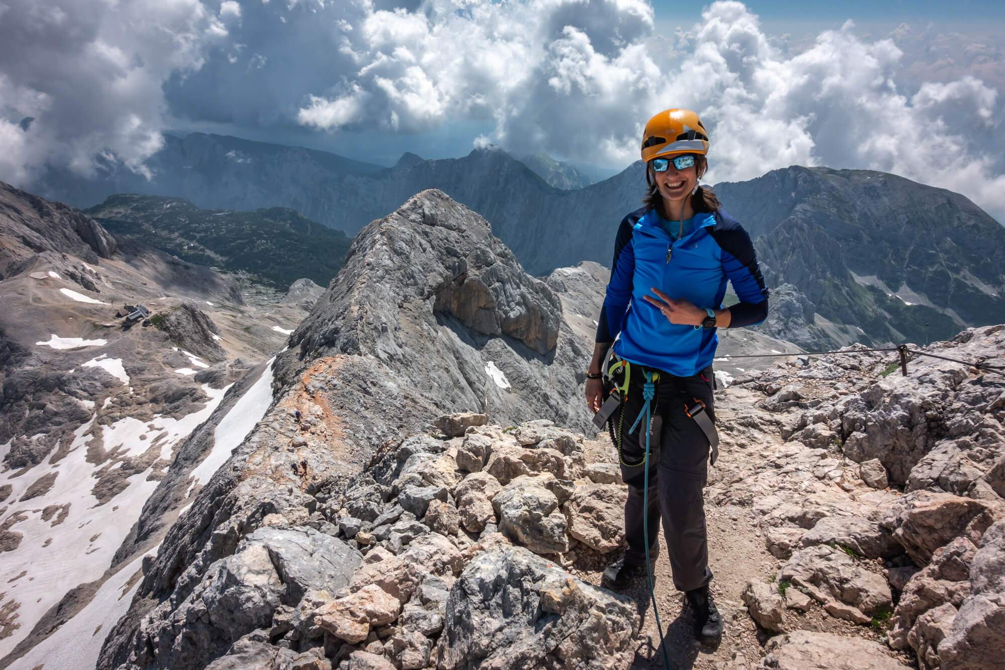Happy Female Climber Ascending Triglav Peak, Small Triglav on the Background Happy Female Climber Ascending Triglav Peak, Small Triglav on the Background