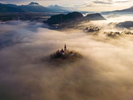 Aerial view of Bled church covered by morning fog