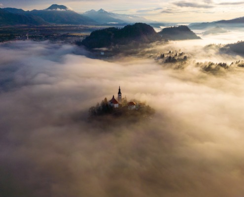 Aerial view of Bled church covered by morning fog