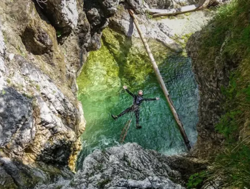 Canyoning Slovenia: Canyoning Bovec near Soca River in Triglav National Park. A man swimming in the canyon.