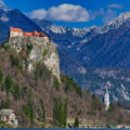 Bled Castle at the top of the rock with mighty mountains in the background