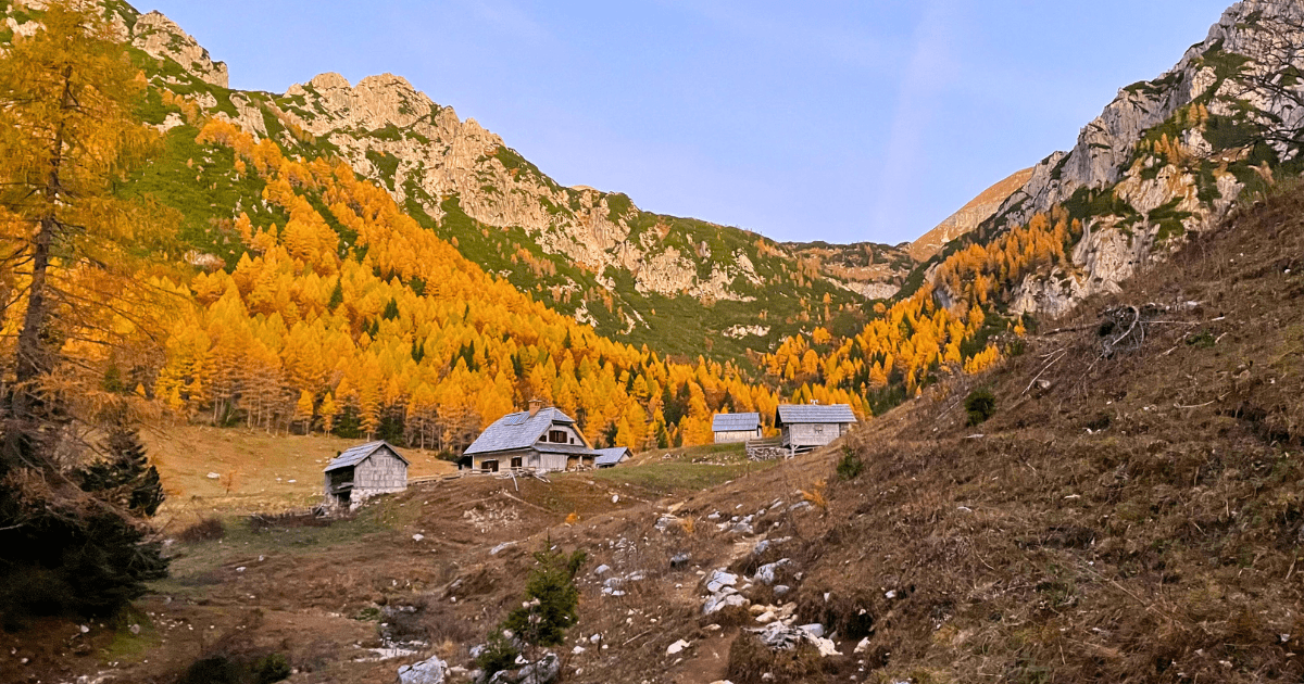 Berghutten langs het pad naar Zelnarica, tegen de ruige achtergrond van de Julische Alpen.