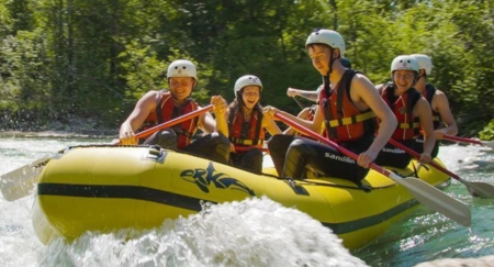 Group of friends is smiling and laughing while rafting on a Sava river
