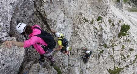 Climbers are seen as the make their way up on a rocky mountain in full safety gear