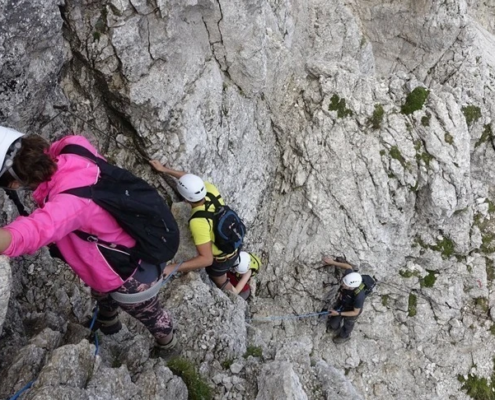 Climbers are seen as the make their way up on a rocky mountain in full safety gear