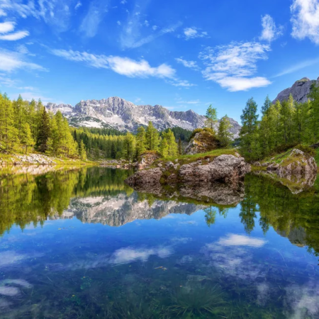 Picturesque mountain lake is seen while reflecting mountains in its steady crystal clear waters