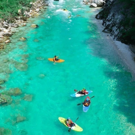 Kayaks are seen from above in crystal blue waters of river Soca river
