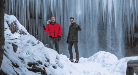 Slovenia winter activities: Two man showing thumbs up while standing under frozen waterfall