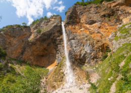 Slovenia Tours: Rinka Waterfall cascading down rocky cliffs surrounded by greenery in Logarska Dolina, Slovenia.