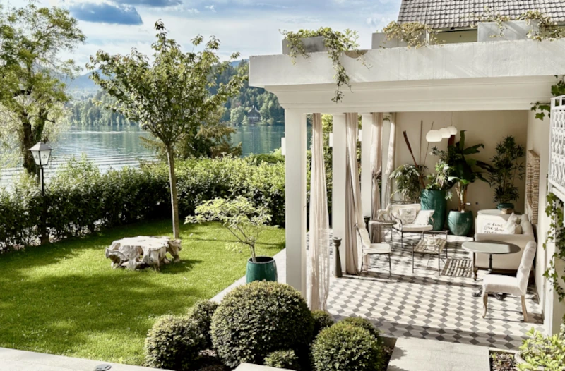 Elegant outdoor seating area in a luxurious garden with a white pergola