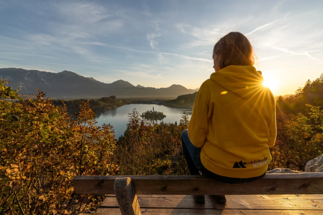 Sunrise above Lake Bled with a person seated on a viewpoint bench