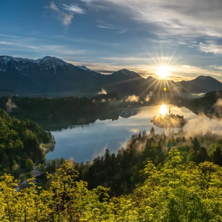 Sunrise over Lake Bled with the island partially covered by morning clouds